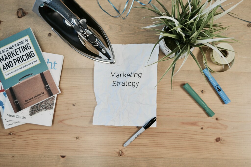 Consultoria de marketing: o que é e como fazer: papel escrito marketing strategy e outros objetos sobre a mesa